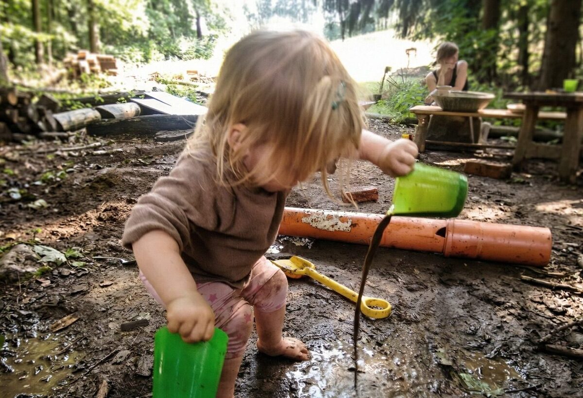 Kleinkind im Wald mit Begleitperson